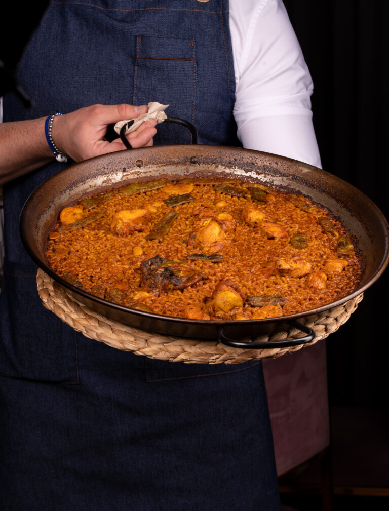 Camarero sirviendo una paella valenciana recién hecha